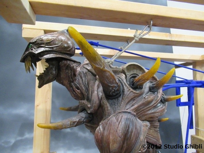 有機的な質感を持つ茶色い背甲に、肩や背中、胸から生えた角が迫力のあるロッドパペットの横向きの写真