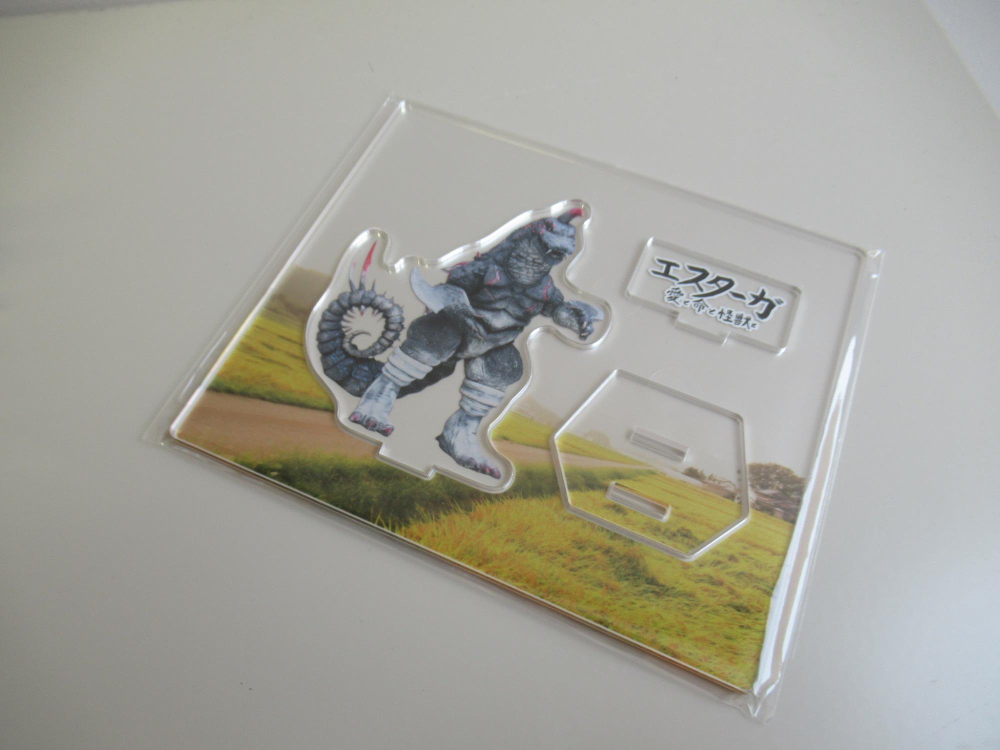 エスターガが印刷された、組み立てる前のアクリルスタンドの写真