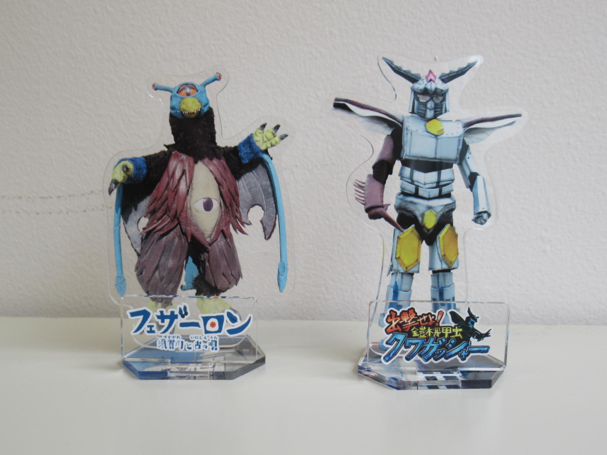 フェザーロンが印刷されたアクリルスタンドとクワガッシャーが印刷されたアクリルスタンドが並んでいる写真