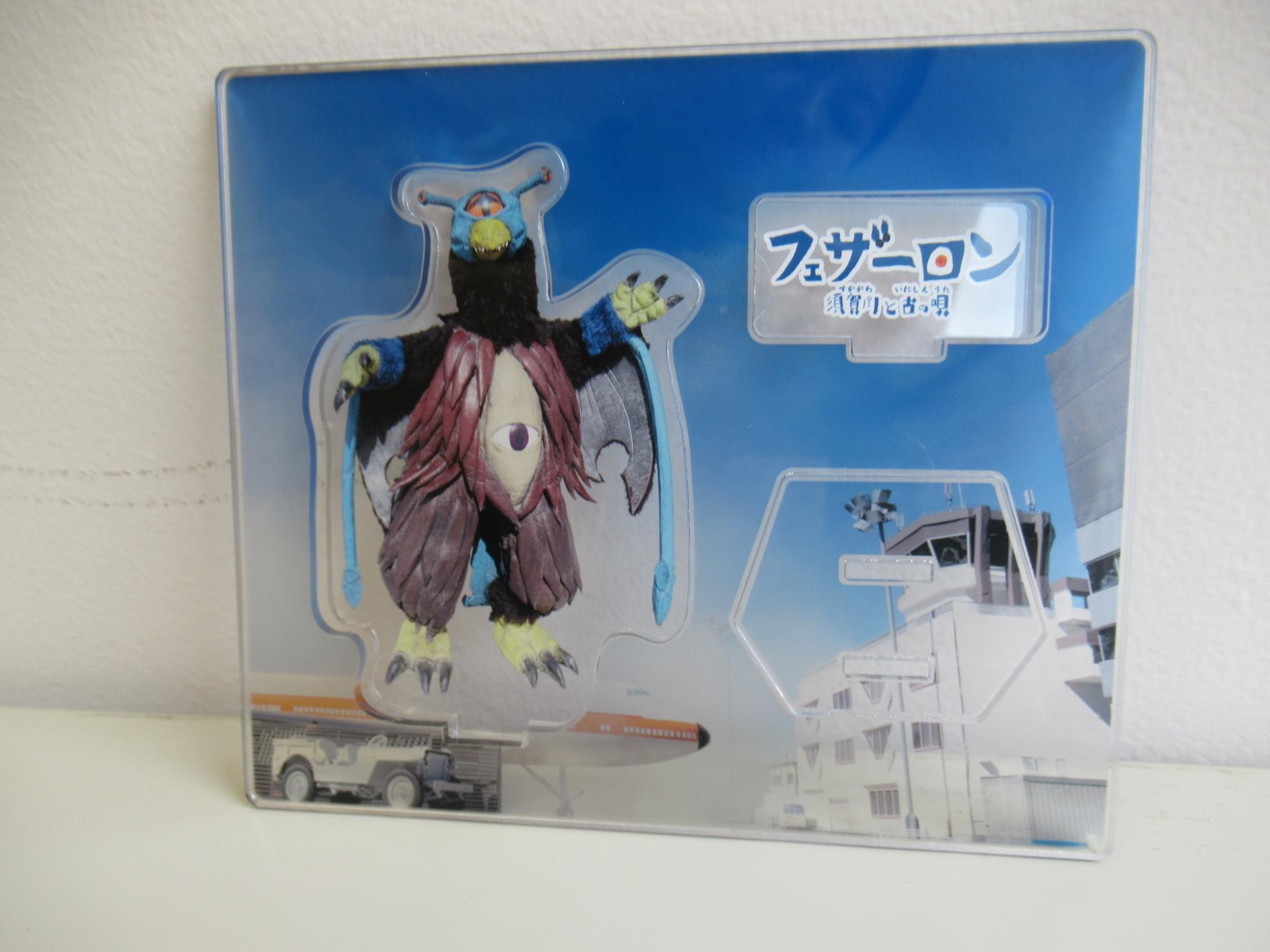 フェザーロンが印刷された、組み立て前のアクリルスタンドの写真