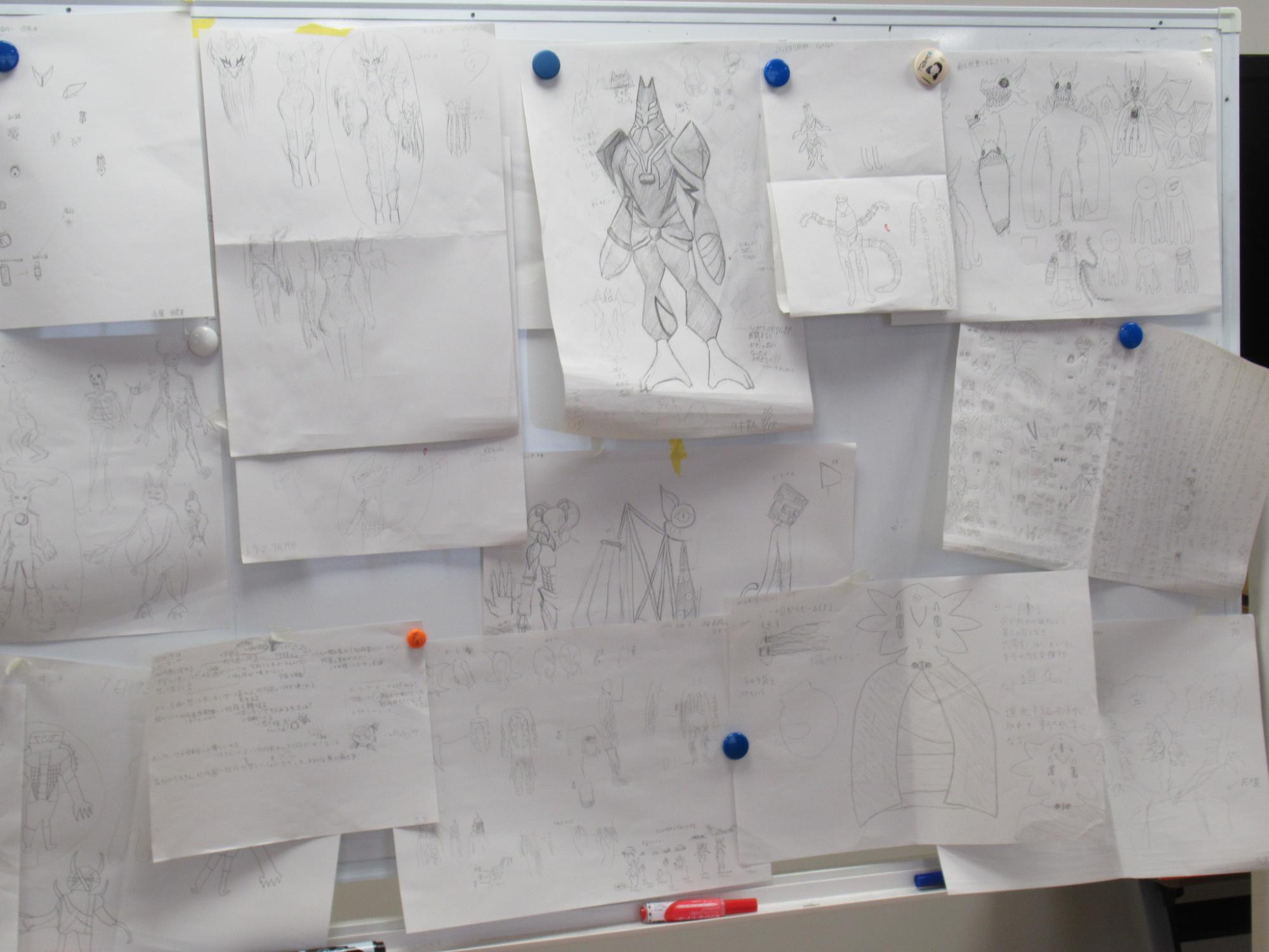 塾生たちが描きだしたアイディアの紙をホワイトボードに貼り出している様子の写真