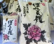 牡丹の花のイラストと「ぼたん姫」の文字が書かれたパッケージの米袋が大小2つ並んでいる写真