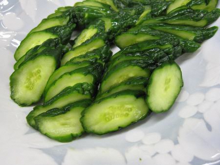 斜め切りにして白い皿に盛り付けたきゅうりの辛子漬けの写真