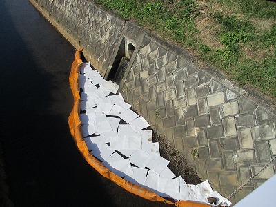 油をせき止めるようオイルフェンス設置している様子