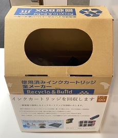 段ボール製で、楕円形の投入口が付いた、使用済みインクカートリッジの回収ボックスの写真