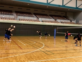 コート内で、生徒たちがボールを使った練習をしている様子の写真