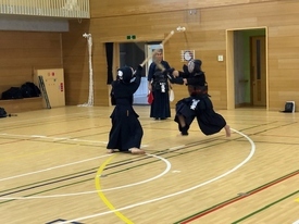 防具を着用した剣士たちが激しく竹刀を交えて、構えをしている写真