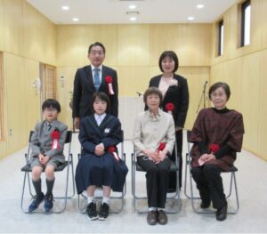 明るい室内で6名の受賞者が、前列の4人は椅子に座り、後列の2人は立って写した記念写真