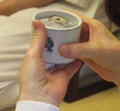 灰がきれいに整えられた白い香炉の正面を向こう側にし、左手親指を香炉の口にかけ安定さている写真