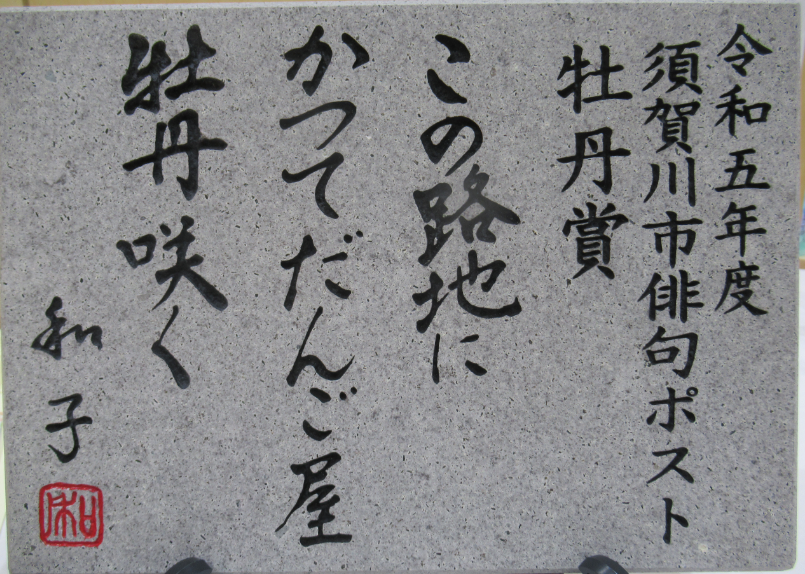 「令和五年度 須賀川市俳句ポスト 牡丹賞 この路地にかつてだんご屋 牡丹咲く 和子」と、力強く情緒ある毛筆体で刻まれた石板の写真