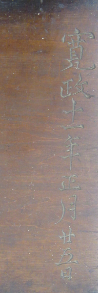 経年変化を感じさせる深い茶色の木板に「寛政十一年正月廿五日」という設立当時を記す日付が縦書きで一文字ずつ丁寧に彫り込まれている写真