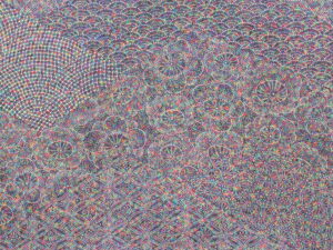 細密な色彩の点と曲線が幾重にも重なり、扇形や輪状の幾何学模様が複雑に広がる布地の文様を近接で捉えた写真
