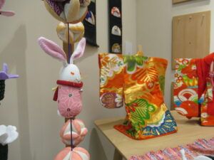 色鮮やかな和柄の小さな着物と吊るし飾りのうさぎ人形が卓上に並び温かな雰囲気を伝える写真