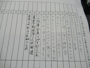 数字と手書きの文字が並ぶ表形式の書類が机上に置かれている様子の写真