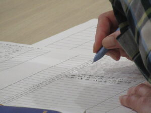 ペンで選句用紙に文字を書き込んでいる手元の写真
