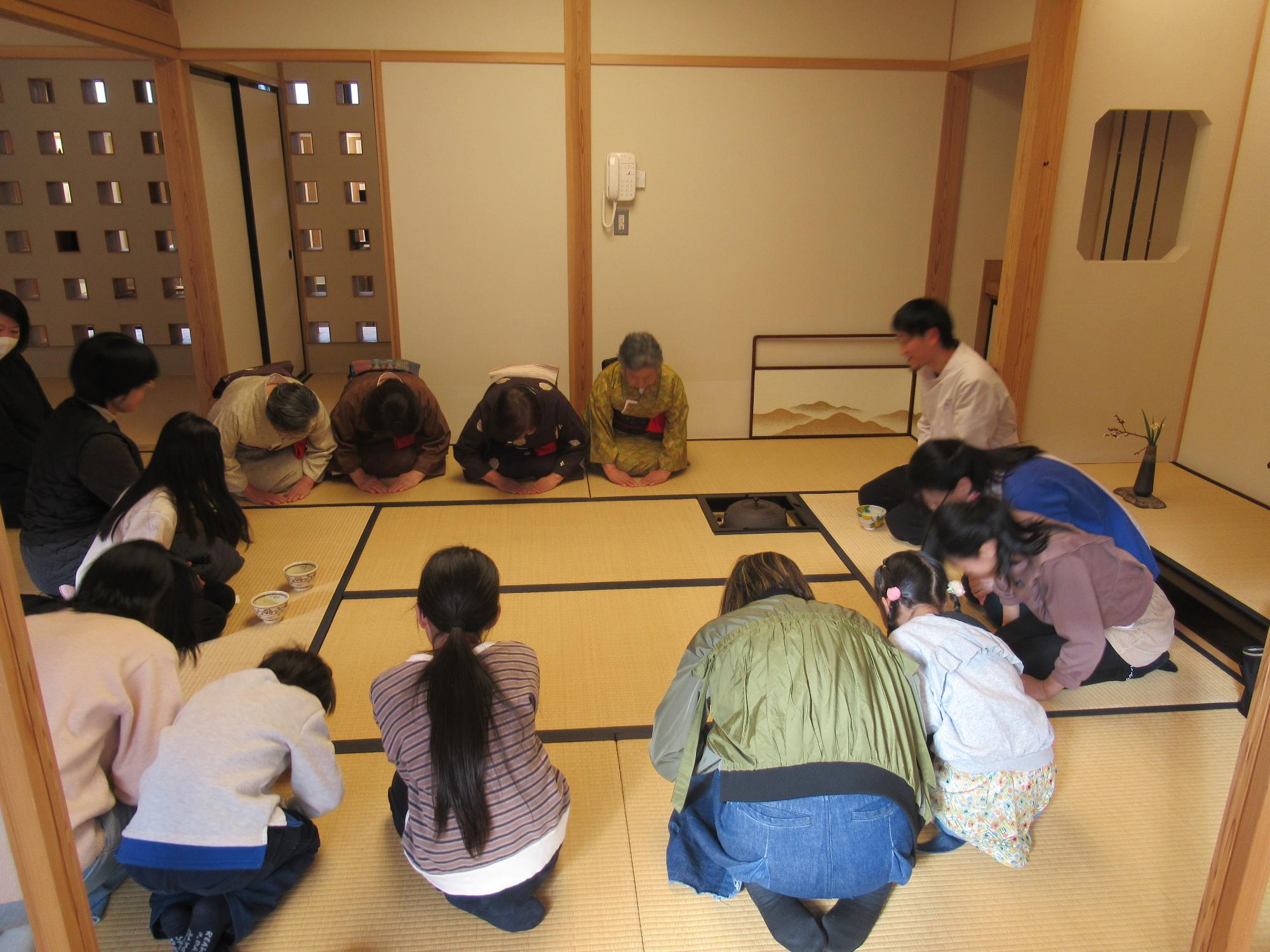 お茶室できちんとおじぎをしてあいさつするようす