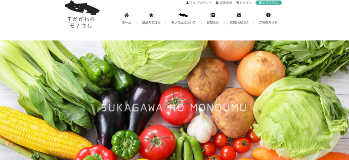「すかがわのモノウム」のロゴマークとナビゲーションメニューの下に、キャベツやトマト、ナス、とうもろこしなど色鮮やかで新鮮な野菜が画面いっぱいに並べられ、中央に白い文字で「SUKAGAWA NO MONOUMU」のサイト名が重なっているバナー画像